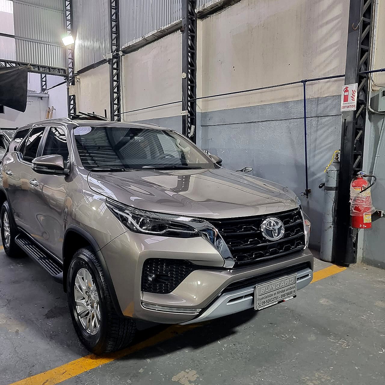 Toyota Fortuner dorada en un taller mecánico.
